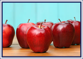 Apples sit on a wooden surface