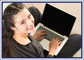 Young lady smiling with a laptop in her lap